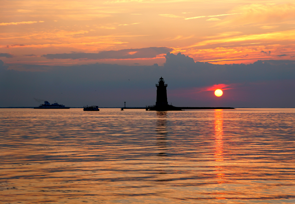 Silhouette of the lighthouse and boats during the sunset at Cape Henlopen State Park, Lewes, Delaware.