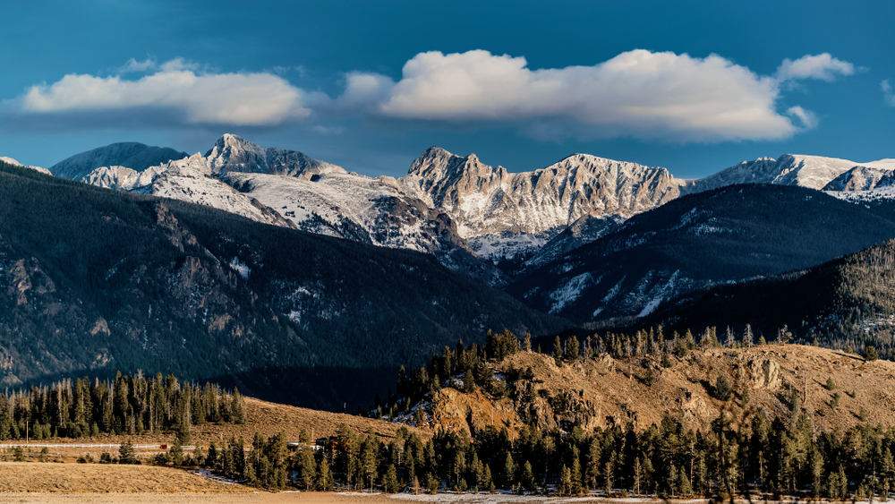 Snow-covered peak views from Granby, Colorado, at sunset; grand entrance to the Rocky Mountains National Park.