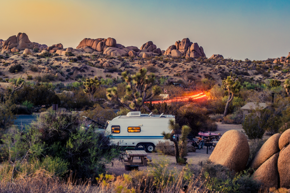 Image of a campground at Joshua tree national park during sunset with a RV or caravan set up to camp.