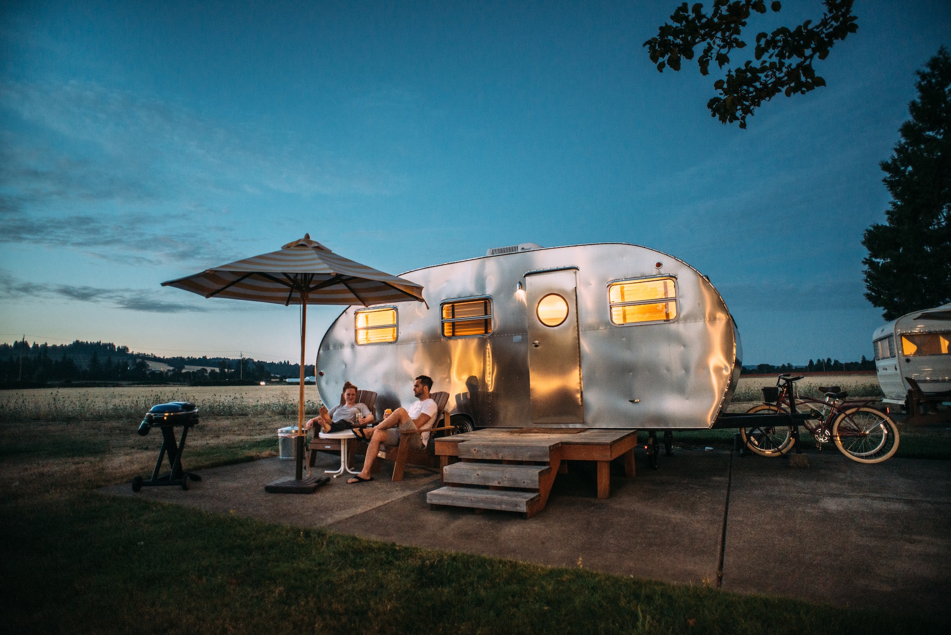 A couple sitting outside enjoying their Airstream trailer.