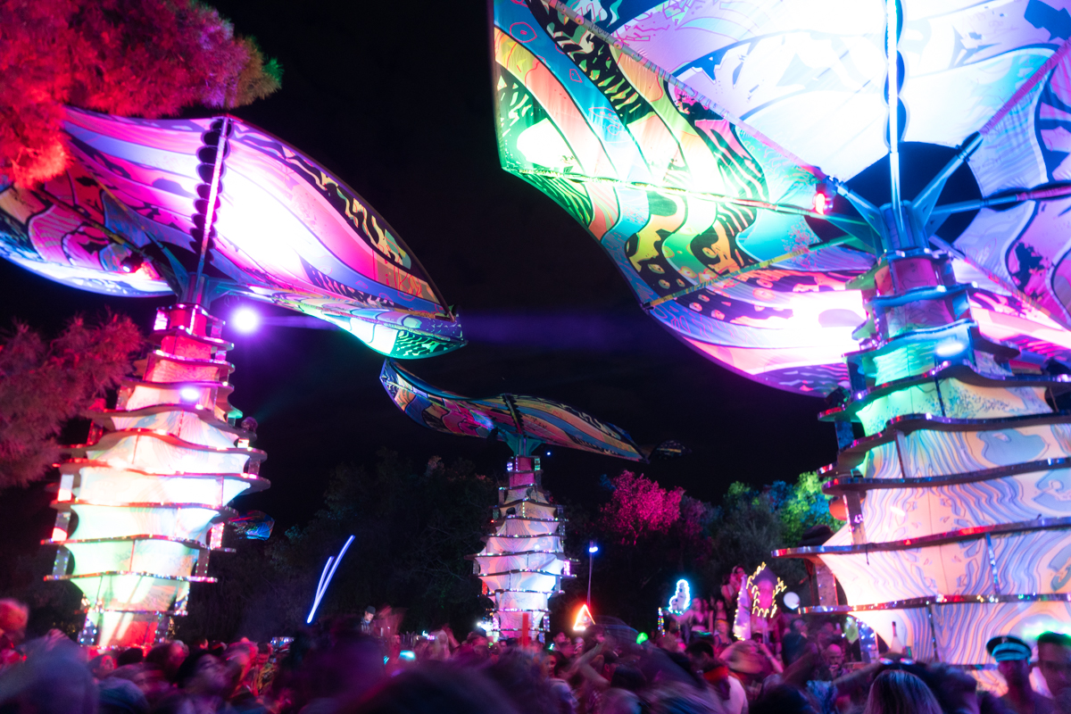 Giant lit up mushrooms at a festival at night.