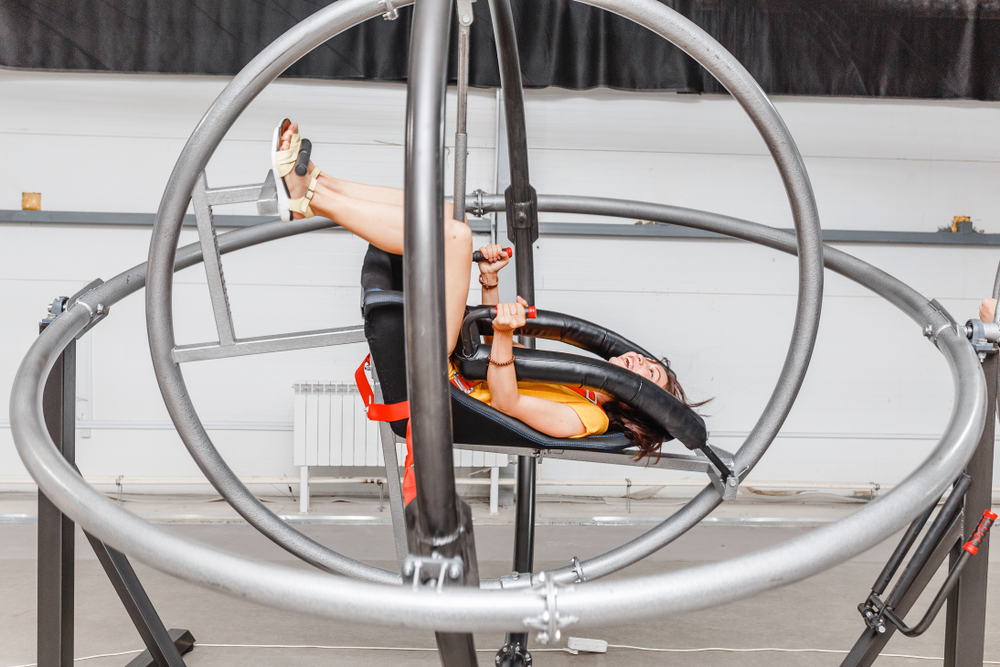 Woman having fun at the astronaut training gyroscope swing.