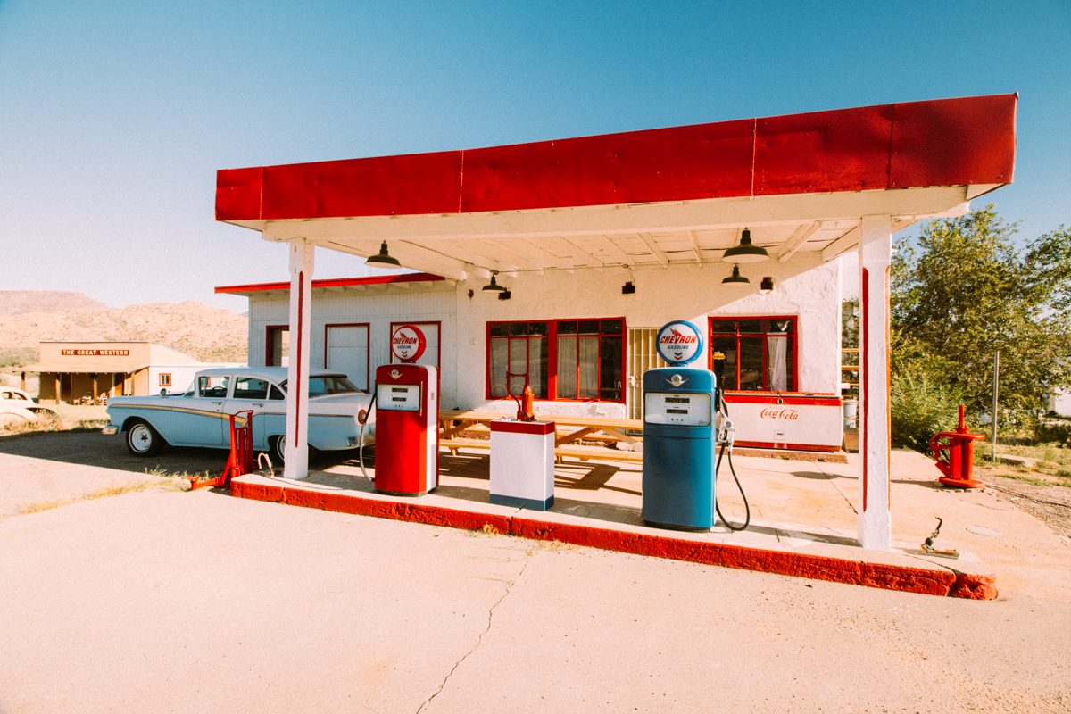 Old school, retro-looking gas station with an old car along Route 66.