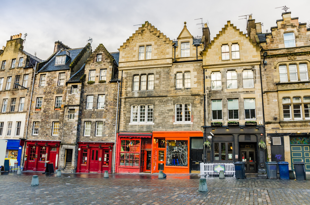 Historic townhouses and colourful shopfronts in Edinburgh's Old Town neighborhood.