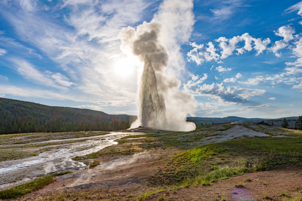 Yellowstone National Park, Wyoming, USA: Old Faithful geyser with the sun behind it.