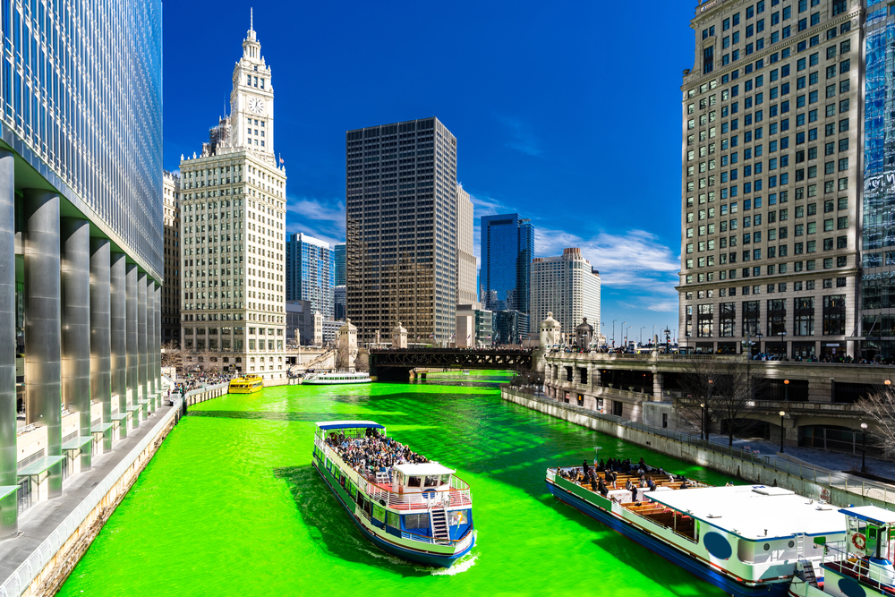 Buildings next to a green river in Chicago during St. Patrick's Day festival.