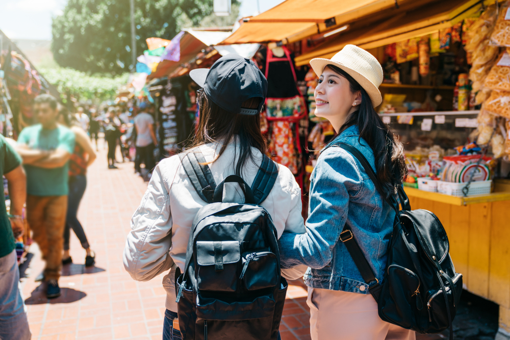 Back view of two female tourists visiting a traditional market in Los Angeles.