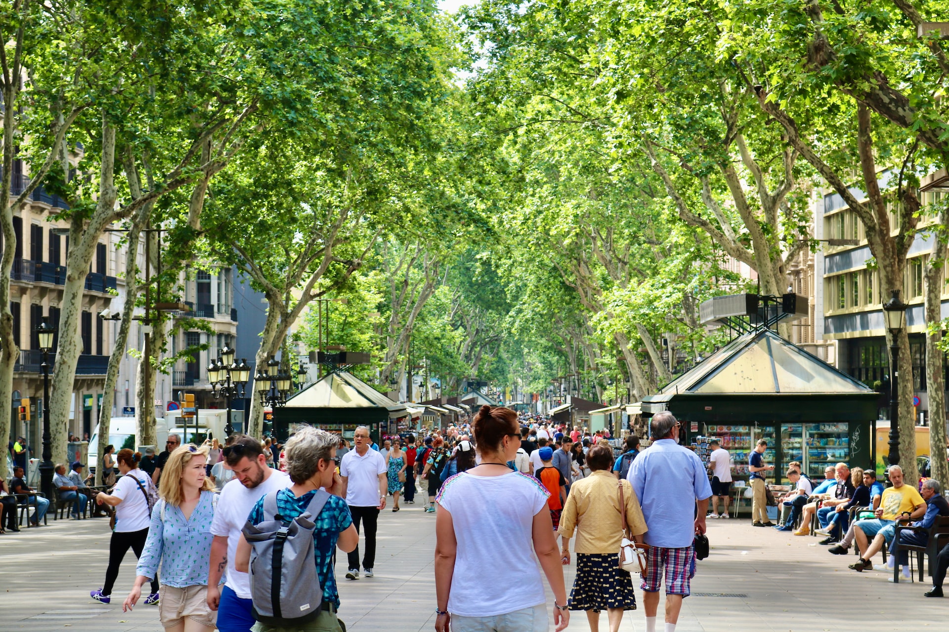 People walking down the busy thoroughfare of Las Ramblas during springtime.