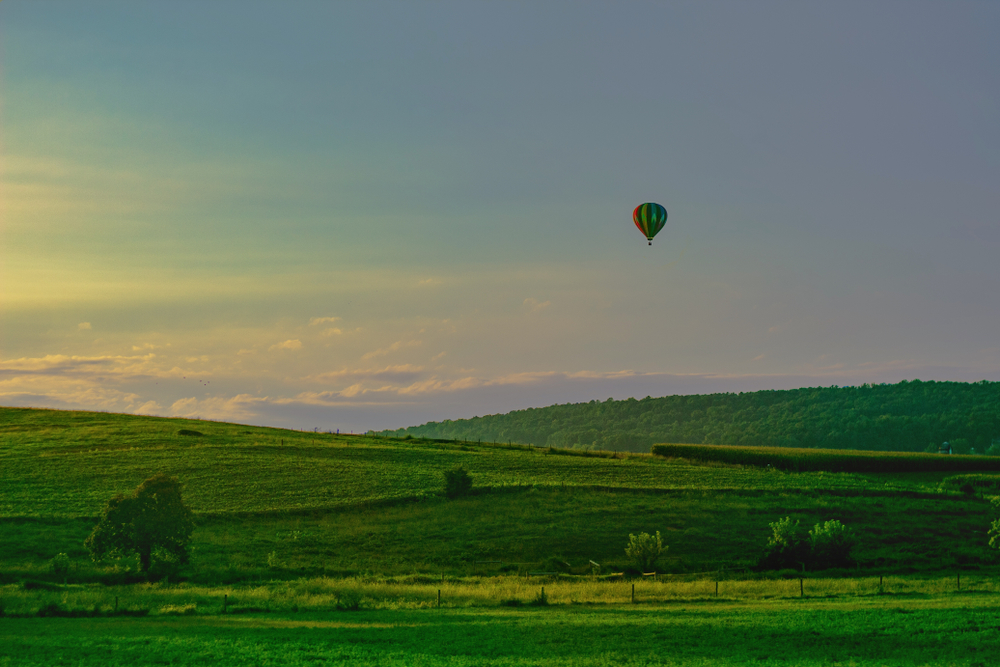 A hot air balloon floating above the Lancaster Amish countryside.