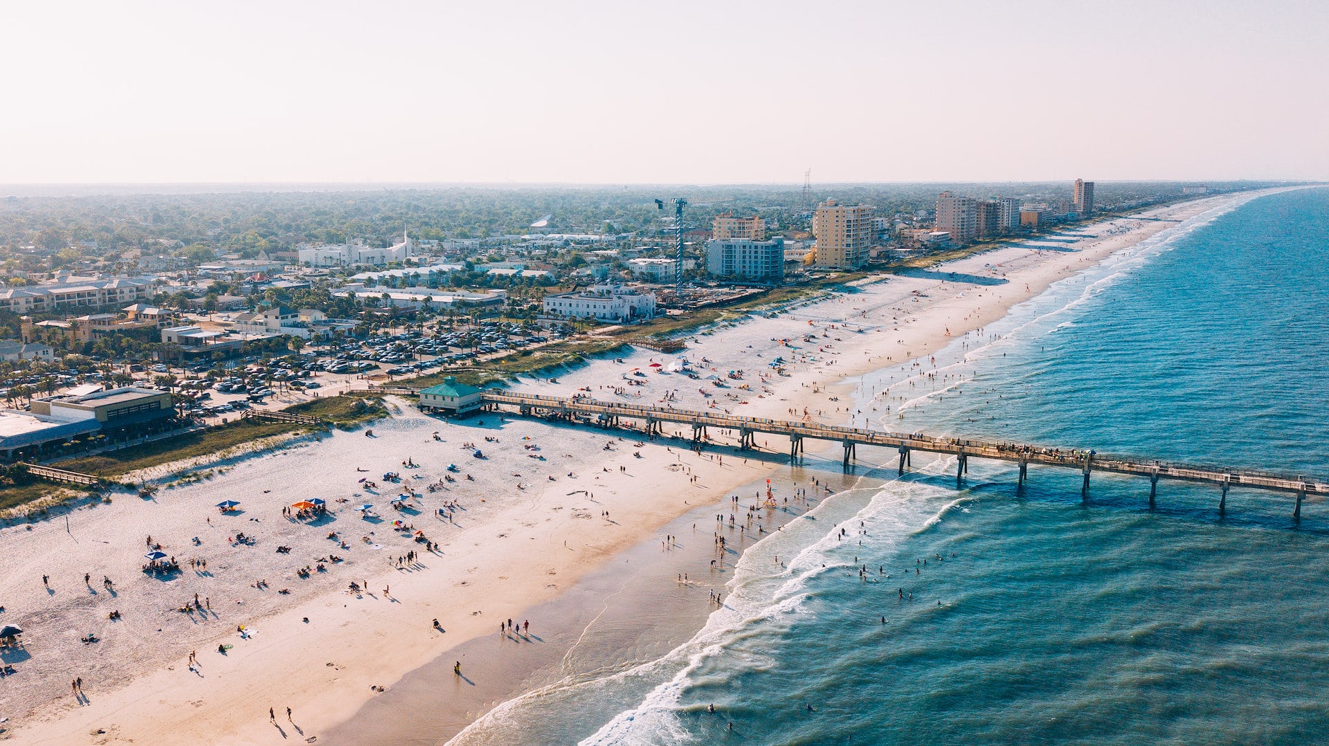 An aerial shot of the pier and people at Jacksonville Beach.