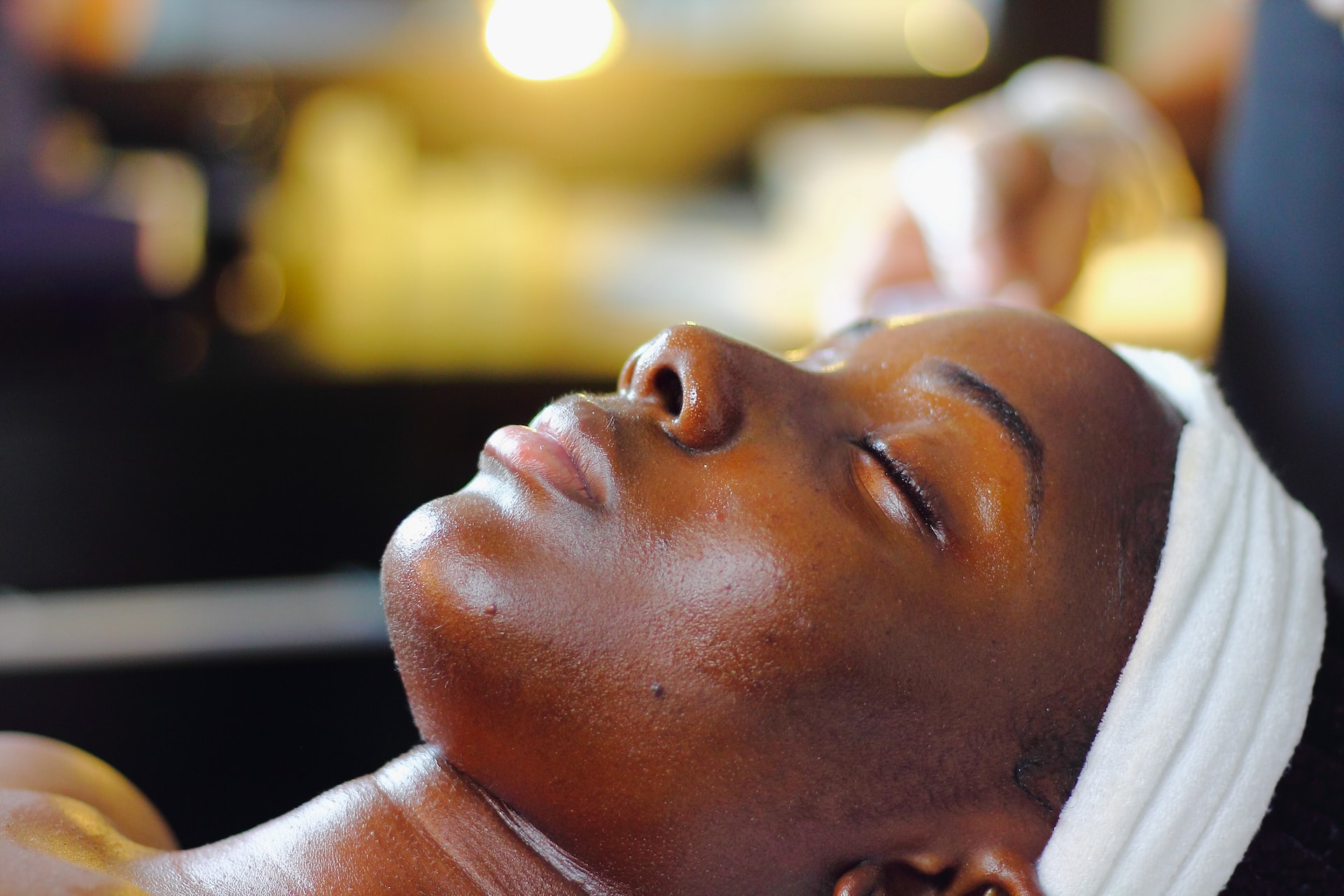 A woman laying down getting a relaxing spa treatment; close-up of her face.