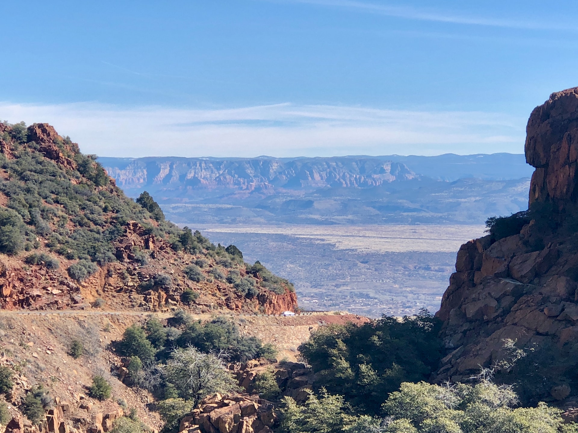 A western United States canyon scene with rising mountains in the background.