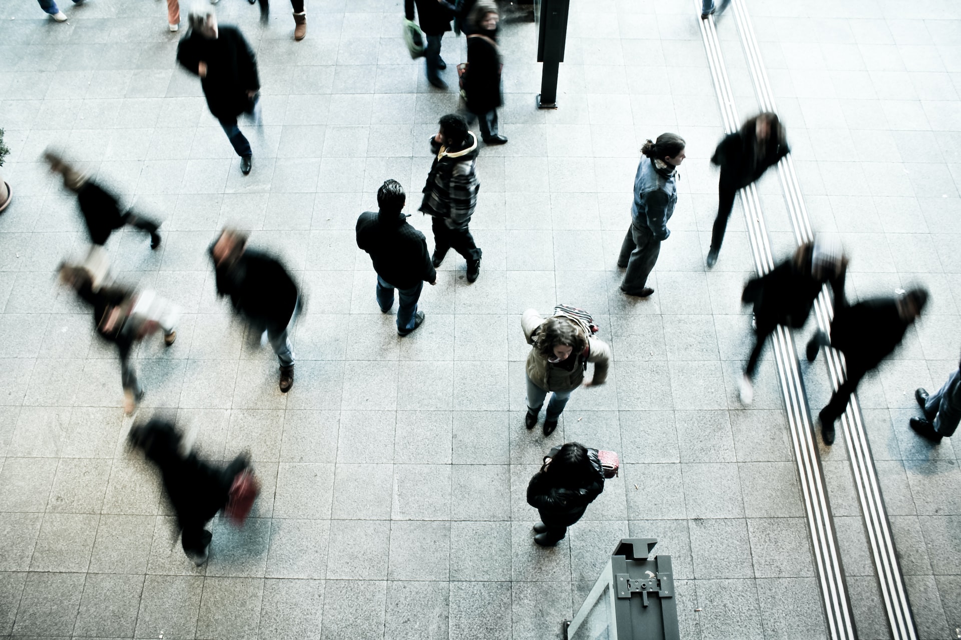 People moving around in a transportation center.