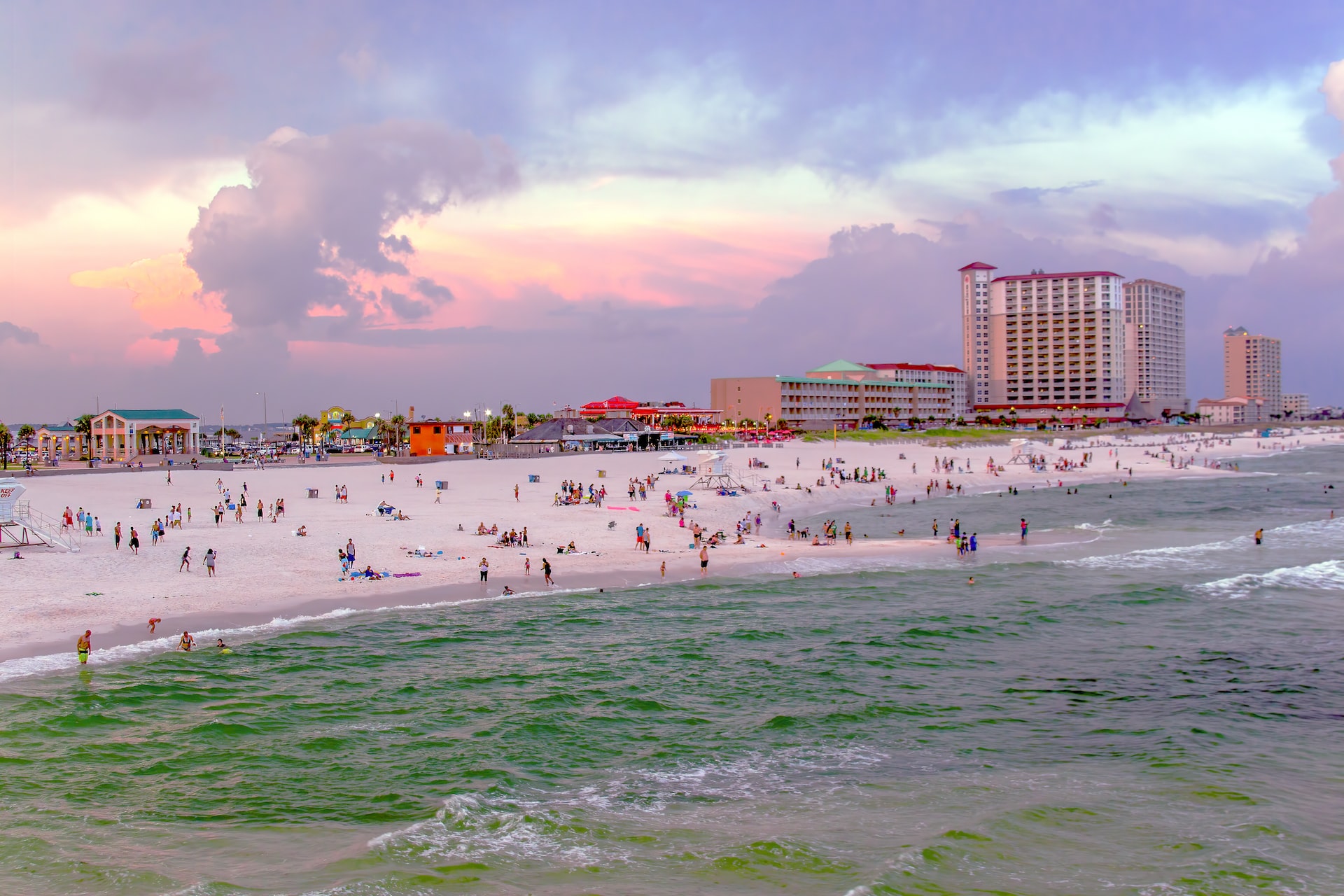 People along the beach of Pensacola, Florida, during sunset.