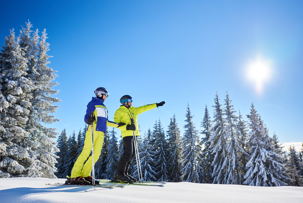 Low angle shot of skiers resting during skiing in sunny winter weather.