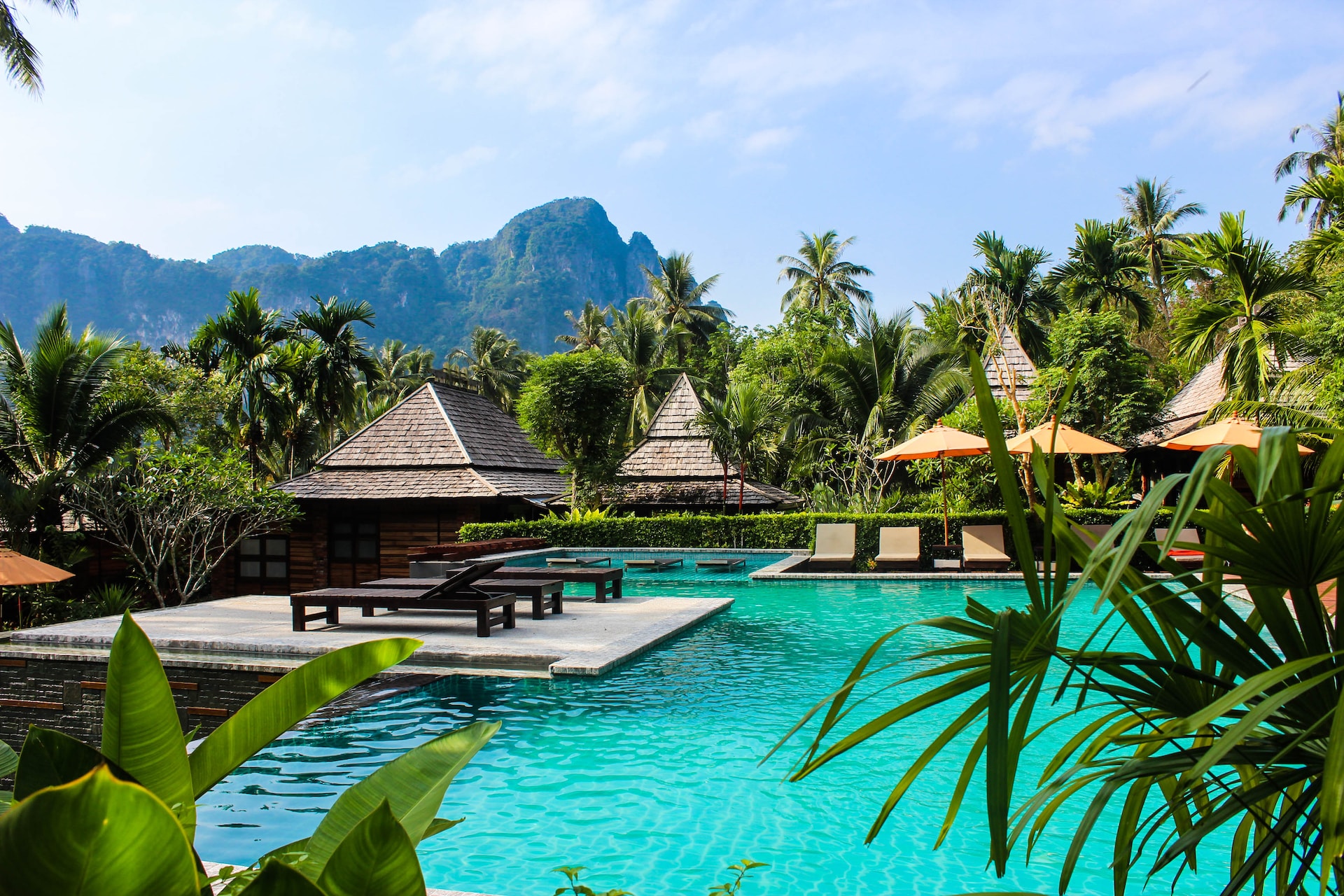 A tropical destination with thatched roofs and aquamarine water.