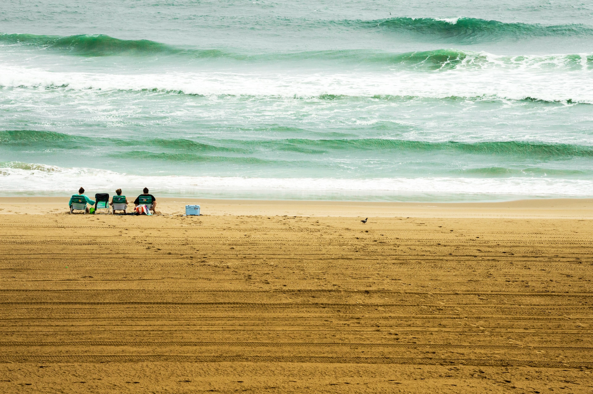 A family takes to the beach early in the morning to beat the crowds and watch the waves roll in.