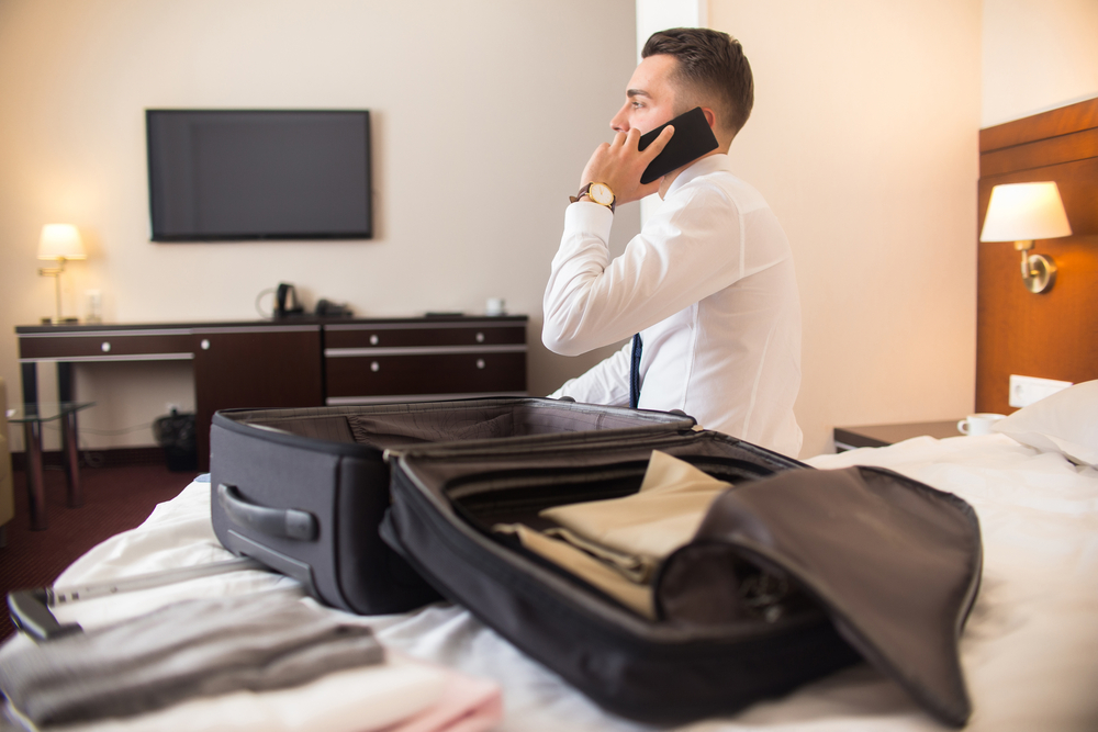 Young male business professional unpacking in his hotel room.