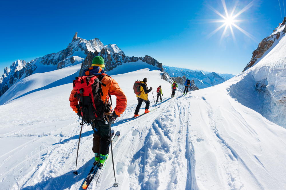 A group of skiers navigating beautiful terrain during midday.