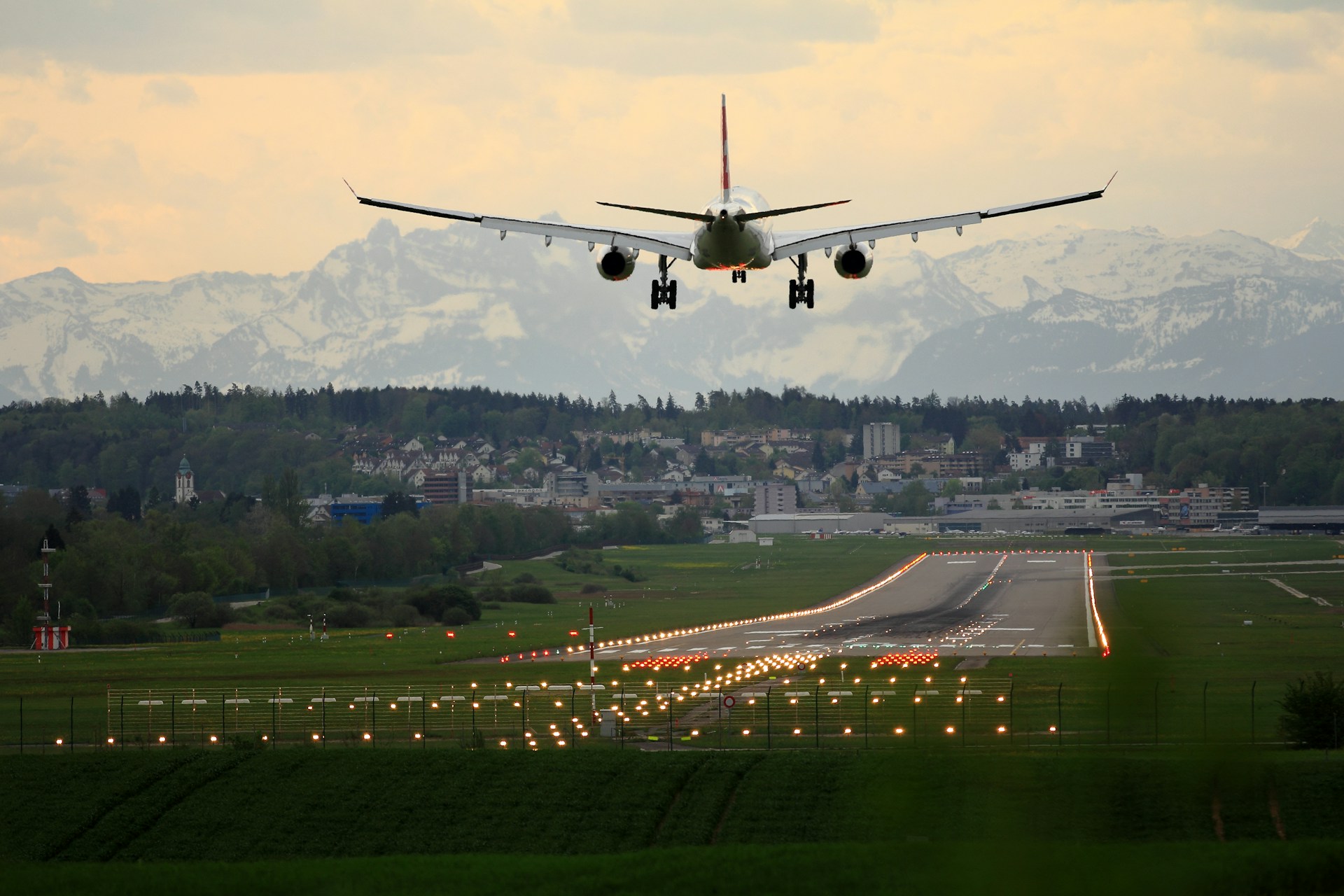 A plane landing on a runway in the Swiss mountains